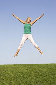 Senior woman jumping in air
