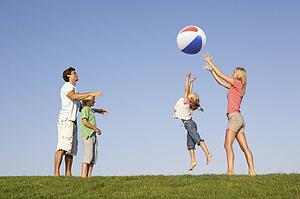 Young family, parents with children, playing in a field