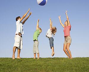 Young family, parents with children, playing in a field