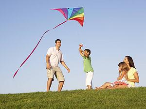 Young family, parents with children, playing in a field