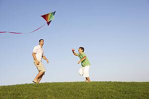 Young parent, father with child, playing in a field
