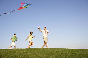 Young family, parents with child, playing in a field