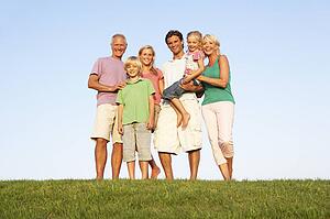 A family, with parents, children and grandparents, posing in a field