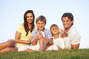 Young parents, with children, posing on a field