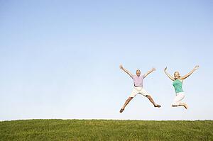 Senior couple jumping in air