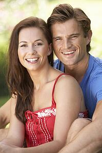 Portrait Of Young Couple Relaxing In Park