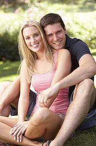 Portrait Of Young Couple Relaxing In Park