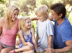 Young parents with children talking in a park