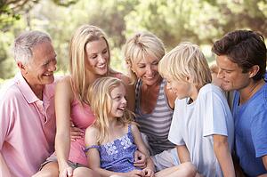 A family, with parents, children and grandparents, relaxing in a park