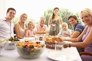 A family, with parents, children and grandparents, enjoy a picnic