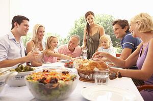 A family, with parents, children and grandparents, enjoy a picnic