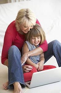 Middle age woman with young girl using laptop computer