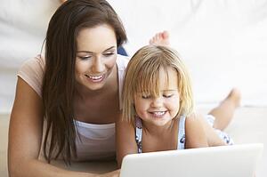 Young woman with girl using laptop computer