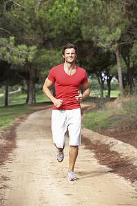 Young man running through park