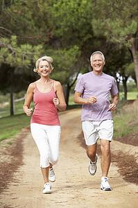 Senior couple running in park