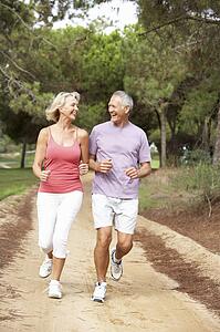 Senior couple running in park