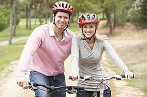 Couple riding bicycle in park