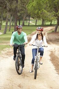 Couple riding bicycle in park