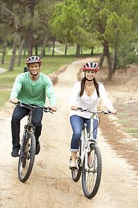 Couple riding bicycle in park