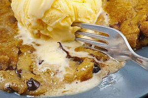 A Fork Cutting Into A Cookie With Ice Cream