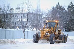 snowplow removes snow off a street; edmonton, alberta, canada