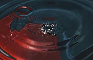 a drop of water hitting a surface of water