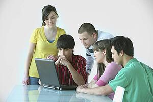 a group of teenagers gathered around a laptop computer; troutdale, oregon, united states of america