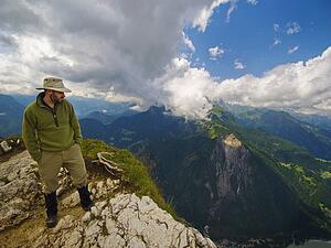 a man standing at the edge of a mountain looking over; veneto, italy