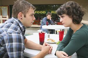 a young couple in a fight as a young man looks on; troutdale, oregon, united states of america