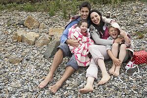Family on beach with blankets