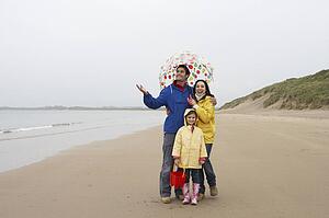 Happy family on beach with umbrella