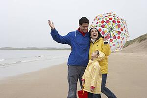 Happy family on beach with umbrella
