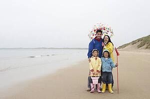 Happy family on beach with umbrella