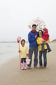 Happy family on beach with umbrella