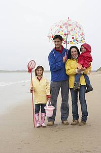 Happy family on beach with umbrella
