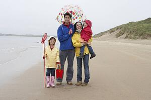 Happy family on beach with umbrella