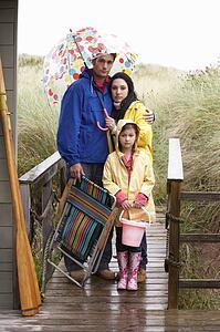 Family on beach with umbrella