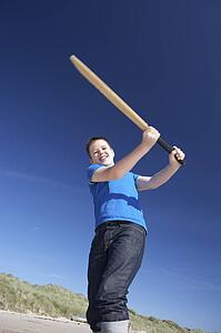 Boy playing cricket on beach