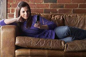 Young woman with phone on sofa