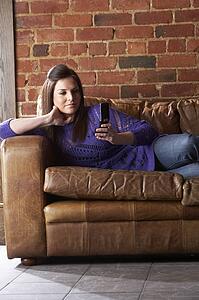 Young woman with phone on sofa