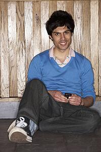 Young man sitting on floor with mobile phone