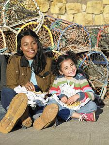 Mother with girl sitting on sand
