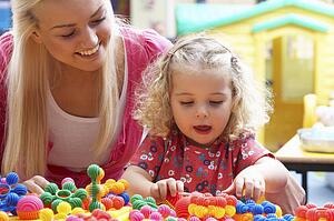Young woman playing with girl