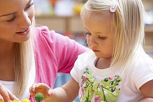 Young woman playing with girl
