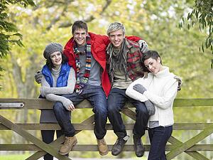 Young friends sitting on fence