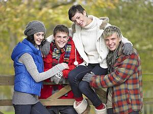 Young friends sitting on fence
