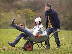 Young couple playing in wheelbarrow