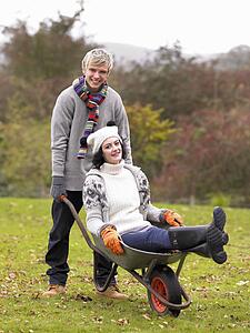 Young couple playing in wheelbarrow
