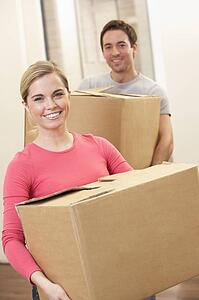 Young couple on moving day carrying cardboard boxes