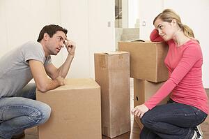 Young couple looking upset among boxes
